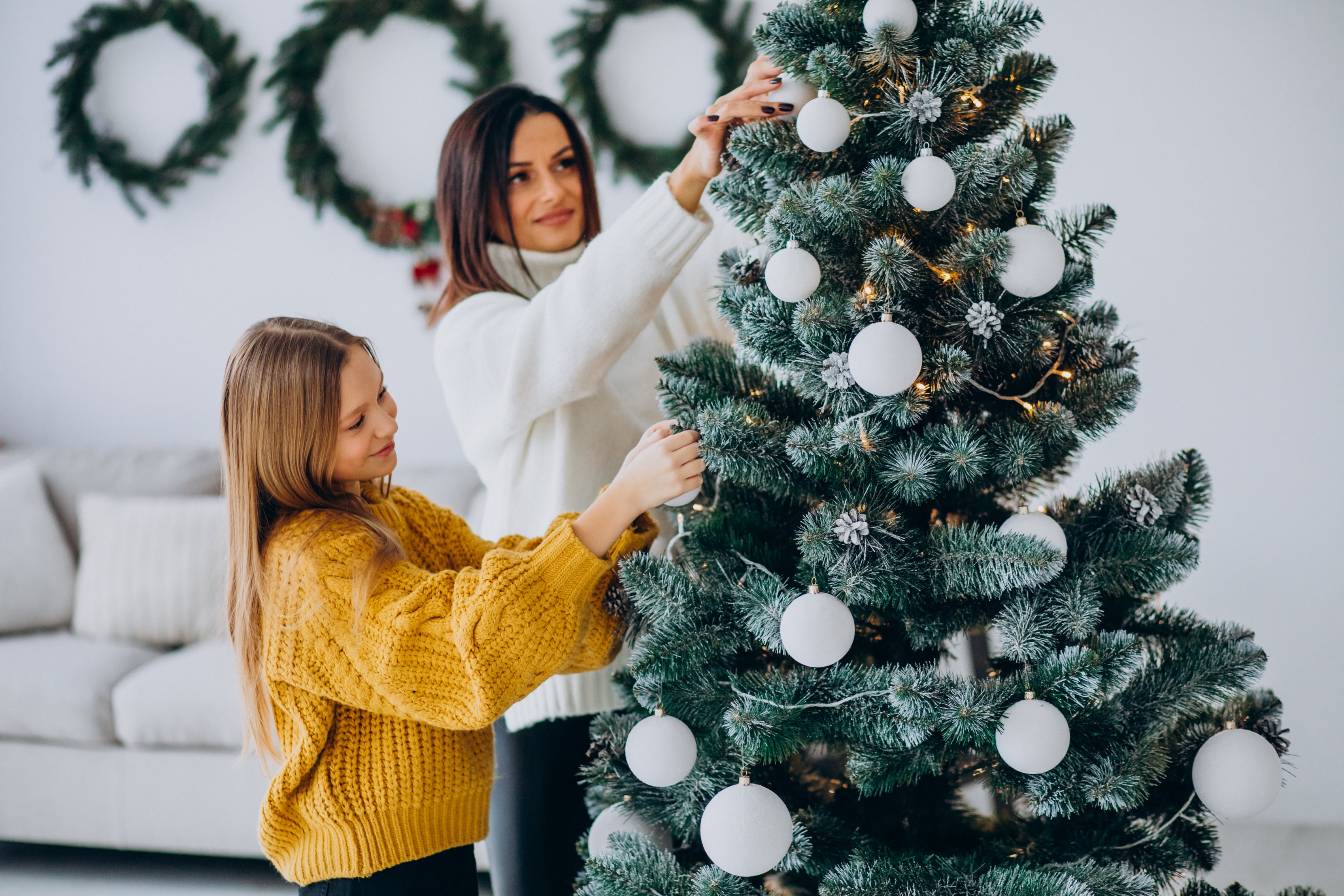 mother-with-daughter-decorating-christmas-tree-min